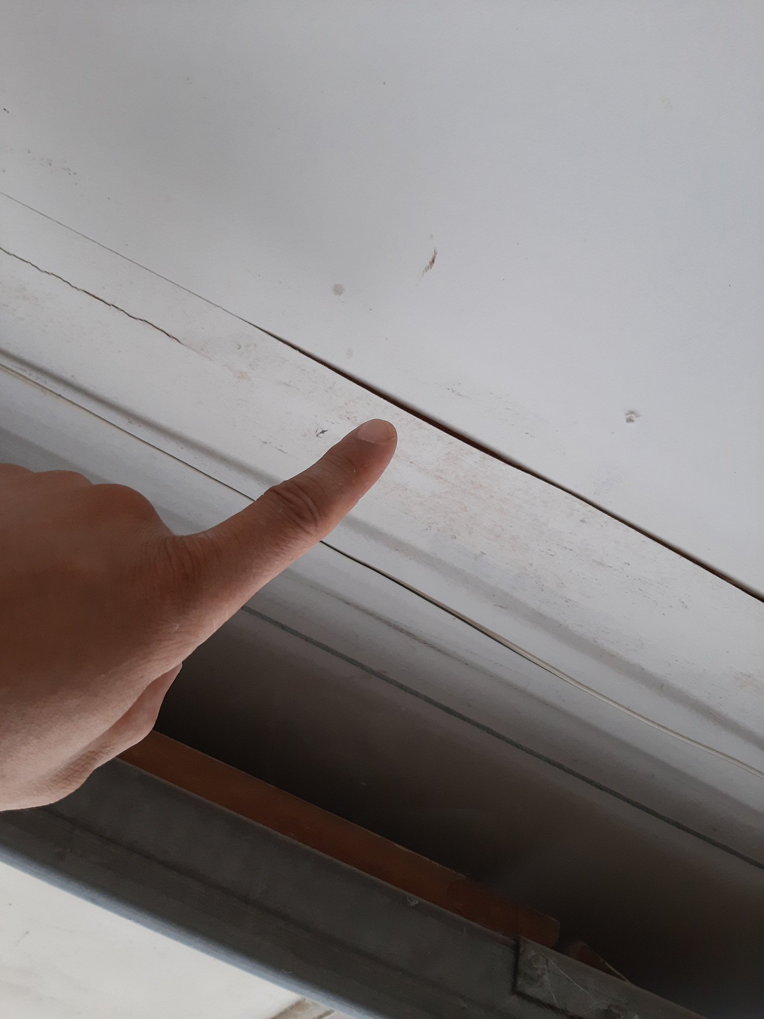 Loose failing drywall tape identified above a garage door opening